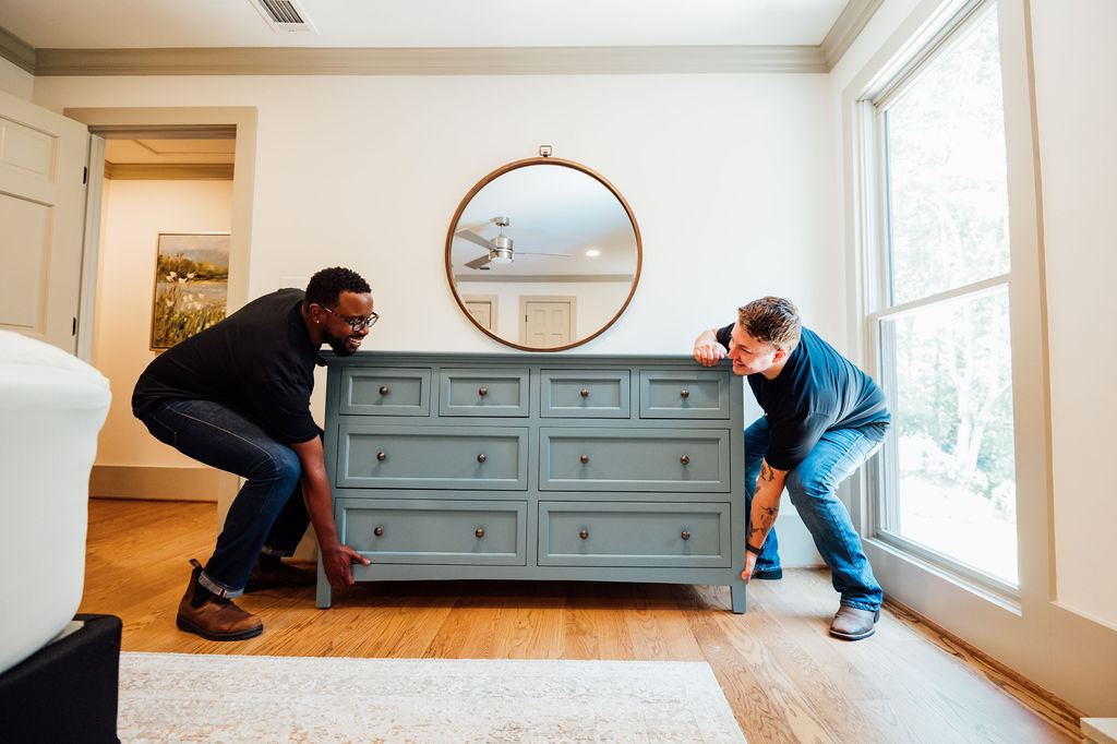 Two Loaders lifting a dresser together during a bedroom set removal