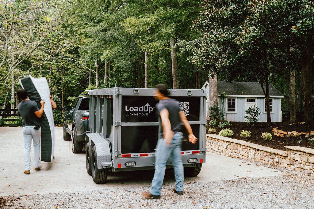 A Loader carrying a mattress to the LoadUp trailer