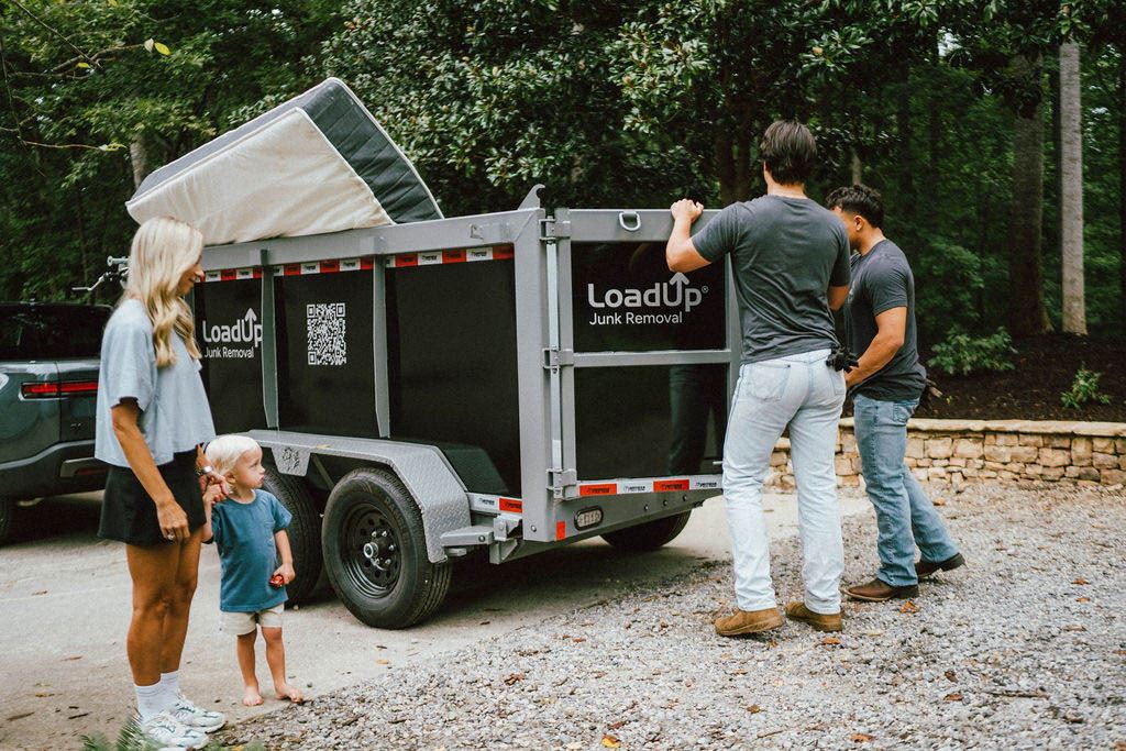 A family watching Loaders close up the LoadUp trailer after a mattress pickup