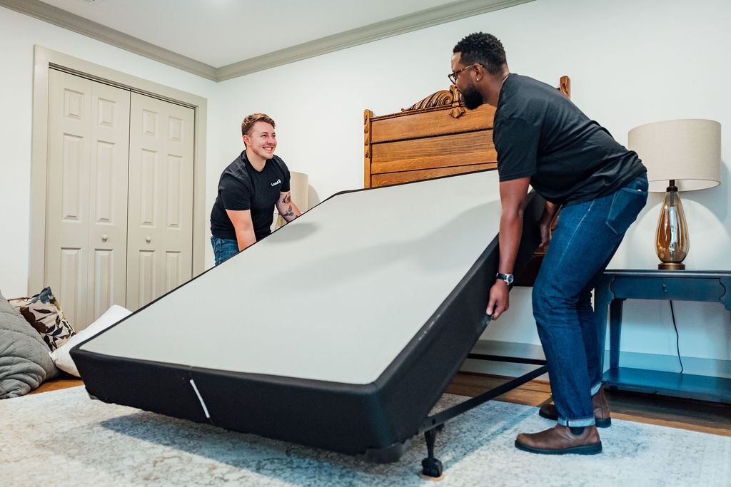 Two Loaders lifting a box spring off the bed frame during a box spring removal