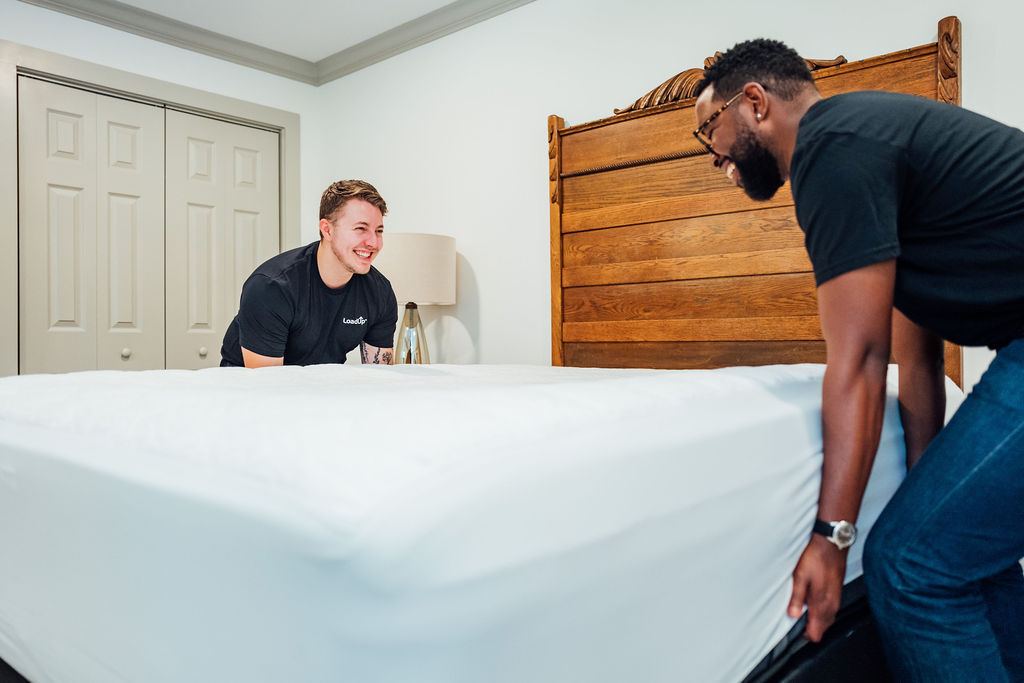 Loaders sharing a laugh while prepping a mattress for removal
