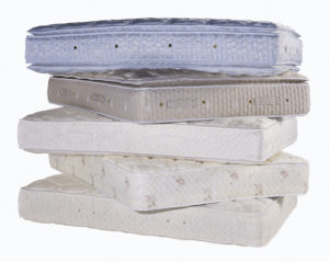 Pile of five used Mattresses on top of each other with a white background
